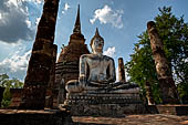 Thailand, Old Sukhothai - Wat Sa Si. Main chedi in Singhalese style with in front the viharn with a sitting Buddha statue. 